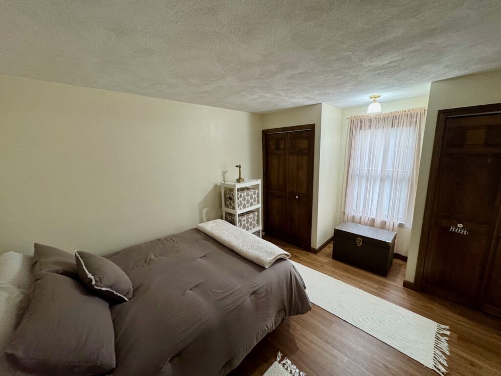 Cozy bedroom with neutral tones and natural light.